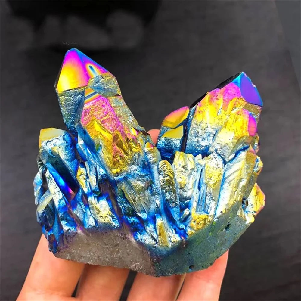 Multicolored crystal held in a hand against a dark background