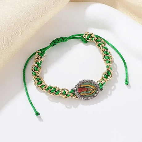 Green bracelet with gold chain and decorative clasp on a light background