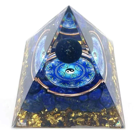 Pyramid-shaped object with blue and gold elements, featuring a yin yang symbol, on a white background.