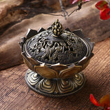 Decorative bronze incense burner on a wooden surface with floral elements.