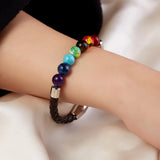 Multicolored beaded bracelet on a wrist against a neutral background