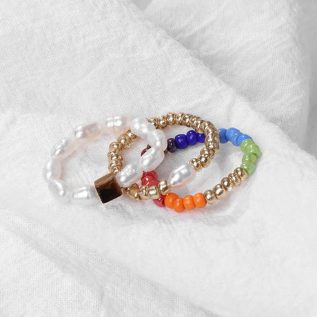 Set of colorful beaded bracelets on a white fabric background