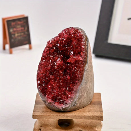 Red crystal geode on a wooden stand with a blurred background