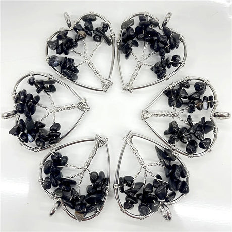Set of six silver pendants with black stones on a white background