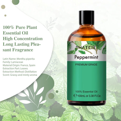 Bottle of peppermint essential oil with green leaves in the background