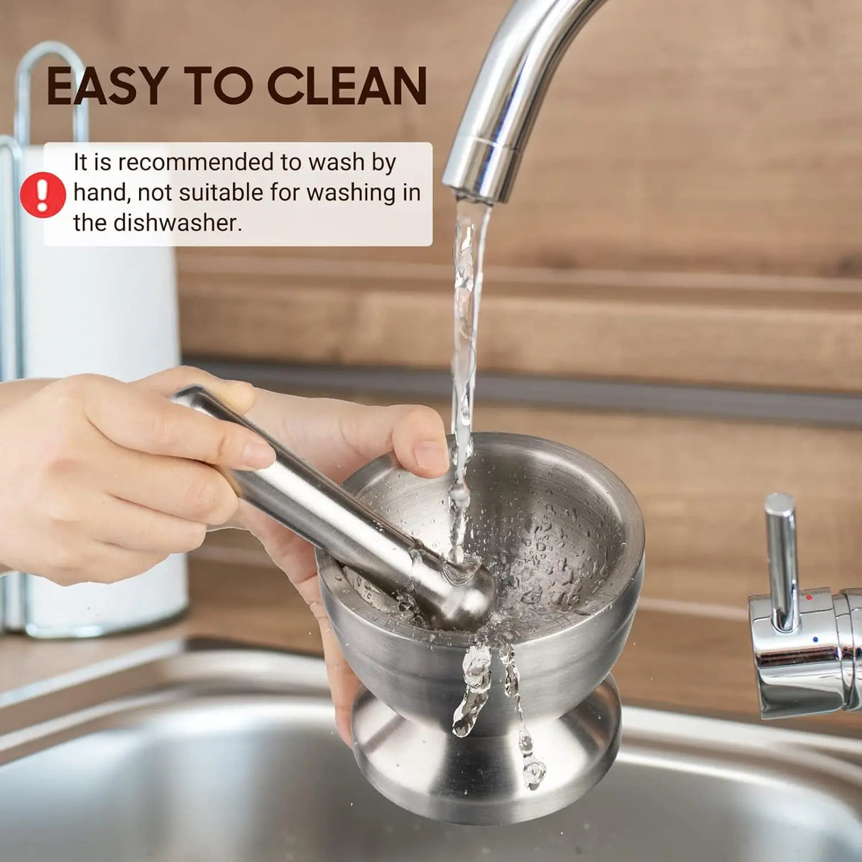 Person washing a metal strainer under running water with text about cleaning instructions.