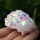 Iridescent crystal brain-shaped object held in a hand with a blurred green background