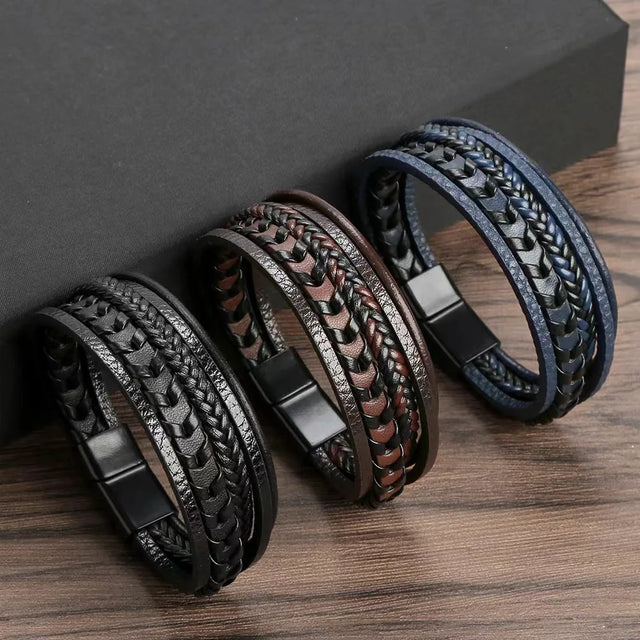 Three braided leather bracelets on a wooden surface with a dark background