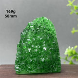 Green crystal rock on a wooden surface with a gray background