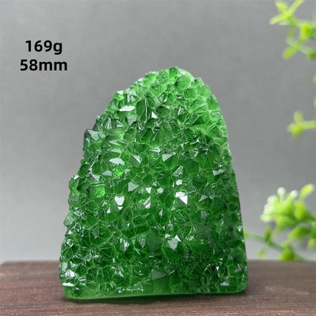 Green crystal rock on a wooden surface with a gray background