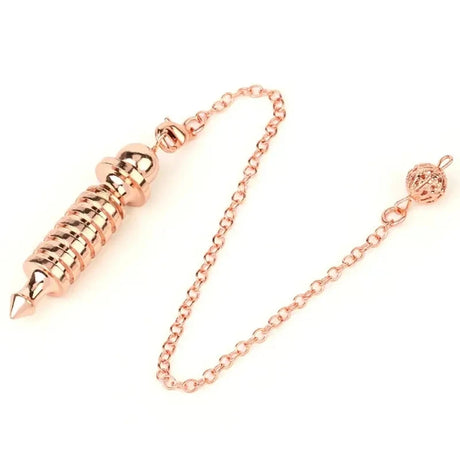 Rose gold chain with a cylindrical rose gold object on a white background