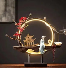 Decorative scene with a pagoda, person, and tree on a dark background