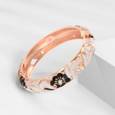 Rose gold bracelet with floral design on a light gray background