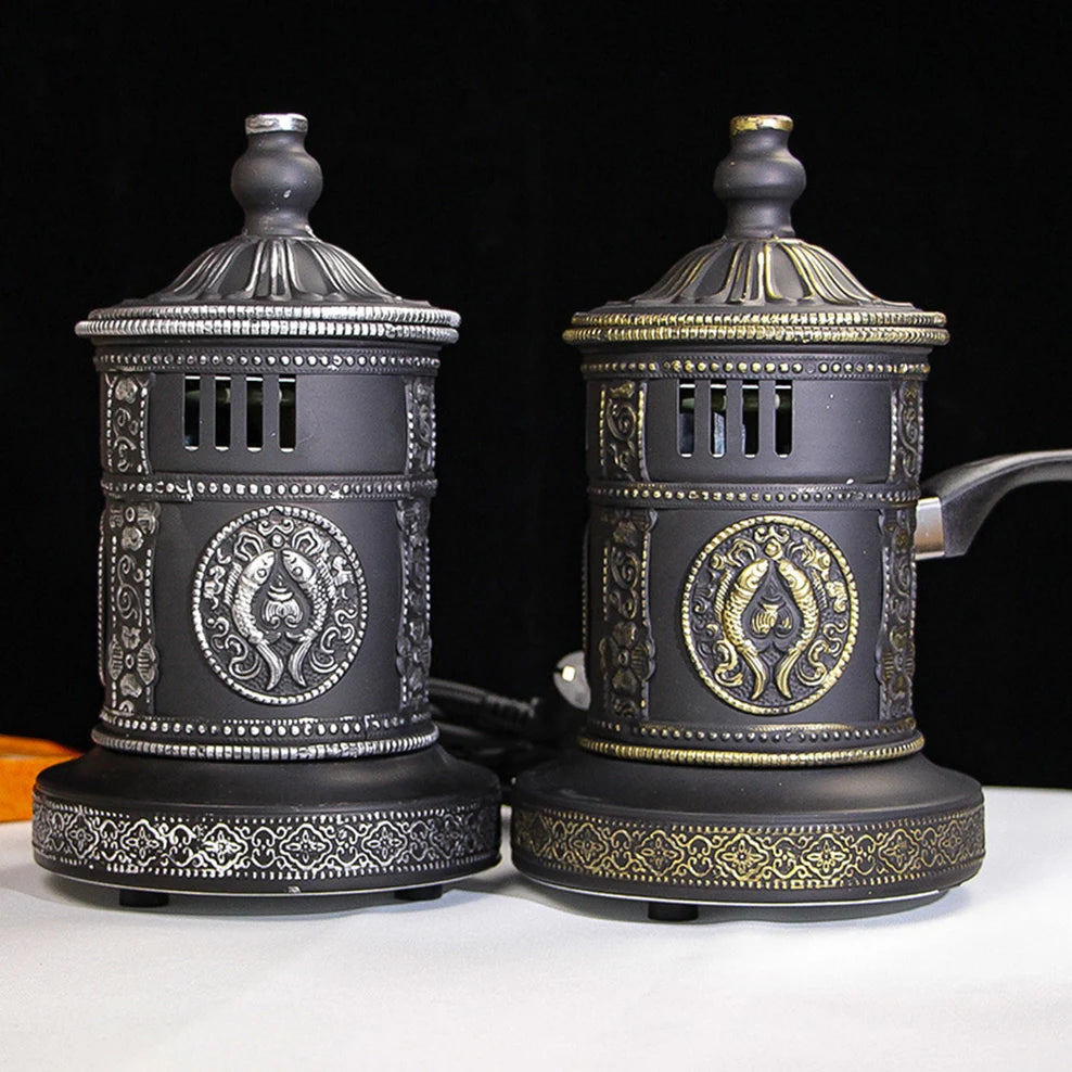 Two decorative coffee grinders with intricate designs on a black background