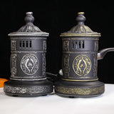 Two decorative coffee grinders with intricate designs on a black background