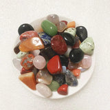 Assorted colorful stones on a white plate with a white background