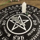 Crystal objects on a black circular mat with white text and symbols