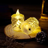 Two decorative LED candles on a wooden surface with a dark background