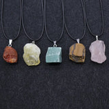 Five stone pendants on black cords against a dark background