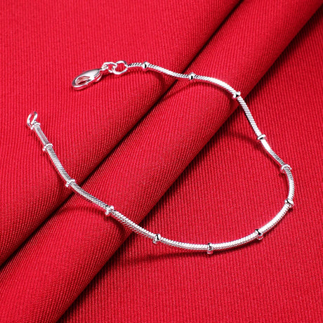 Silver bracelet on a red fabric background