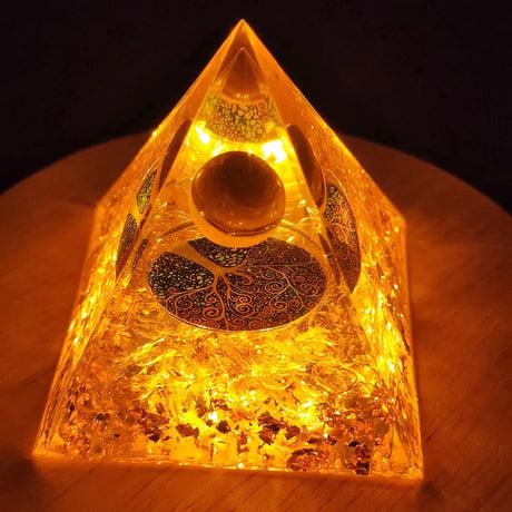 Pyramid-shaped light with intricate design on a wooden surface