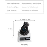 Black dragon-shaped object on a digital scale with dimensions and weight displayed.