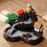 Decorative miniature landscape with a pond, trees, and buildings on a wooden surface