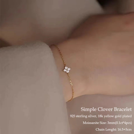 Simple clover bracelet with diamonds on a wrist, displayed against a neutral background.
