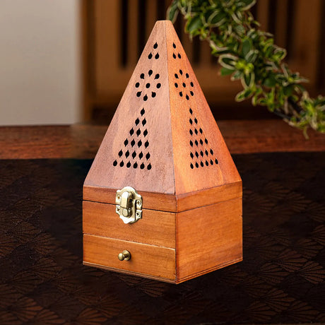 Wooden incense burner with decorative patterns on a dark surface
