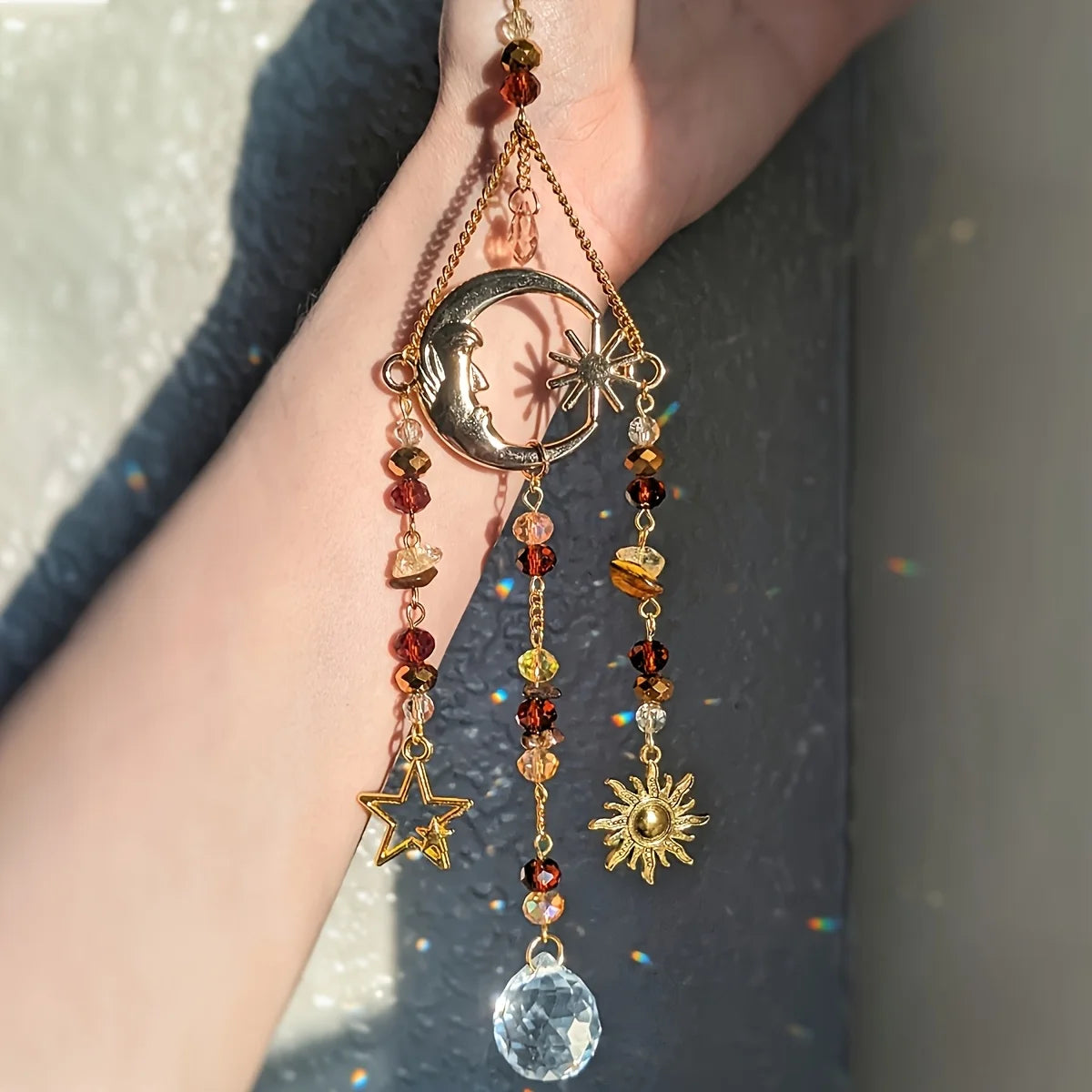 Decorative keychain with celestial symbols and beads on a blurred background