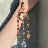 Decorative keychain with celestial symbols and beads on a blurred background