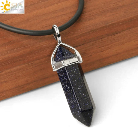 Black crystal pendant on a leather cord with a wooden background