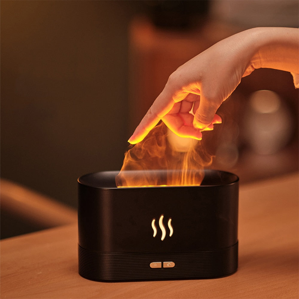 Black electronic device with flames emerging, resembling a humidifier or diffuser, on a wooden surface.
