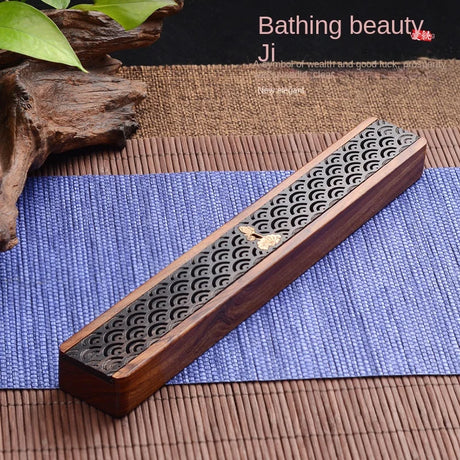 Wooden incense holder with decorative patterns on a blue mat