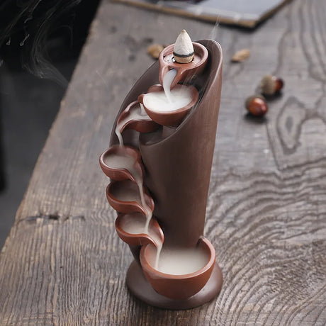 Ceramic incense burner with smoke on a wooden surface