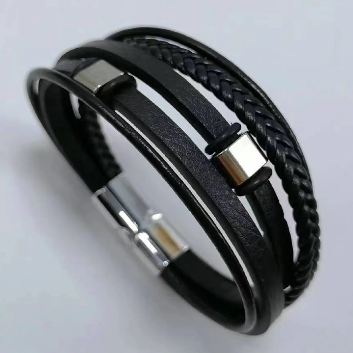 Black braided leather bracelet with silver metal accents on a light gray background