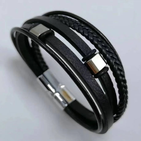 Black braided leather bracelet with silver metal accents on a light gray background