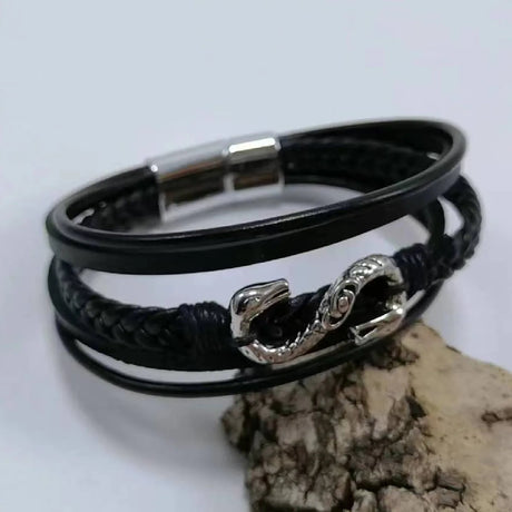 Black leather bracelet with silver clasp on a light gray background