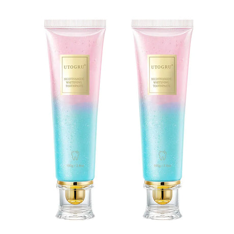 Two tubes of UTOGRU toothpaste with gradient pink to blue design on a white background