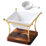 White ceramic bowl with gold rim on a wooden base, accompanied by a white ladle.