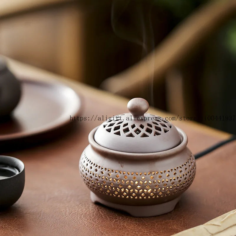Ceramic incense burner with intricate design on a wooden surface