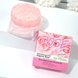 Solid shampoo bar with packaging labeled 'Rose' on a white surface.