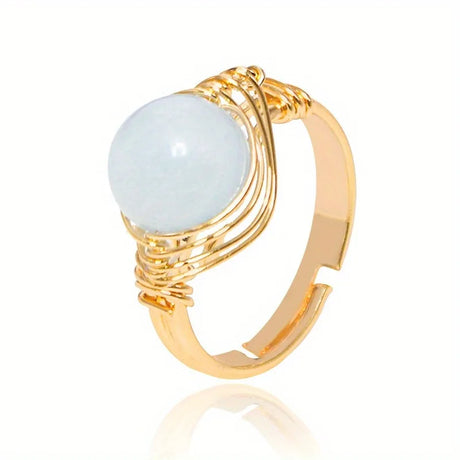 Gold ring with a light blue gemstone on a white background