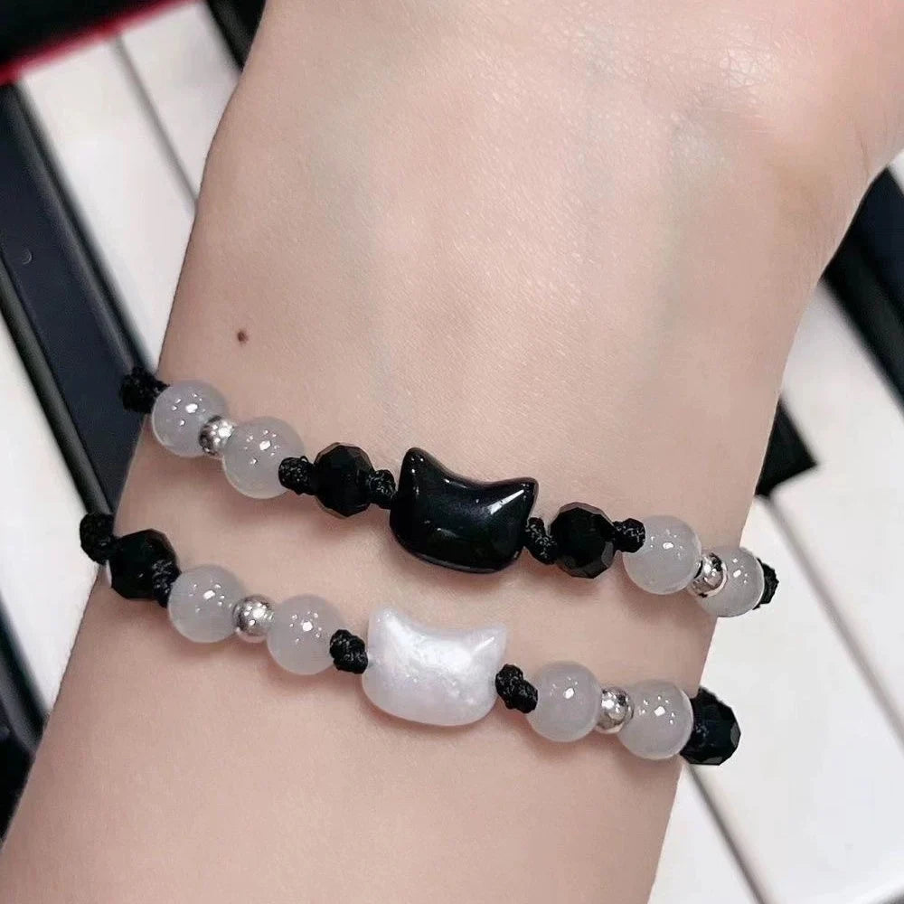 Bracelet with black and white beads on a wrist against a blurred background