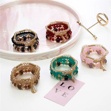 Colorful beaded bracelets on a white surface with a 'LOVE' card.