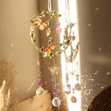 Decorative hanging with butterflies and crystals in front of a window with sunlight streaming through.