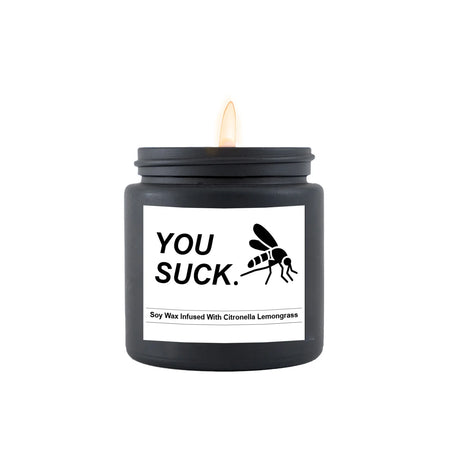 Black candle with 'YOU SUCK.' label and mosquito graphic on a white background
