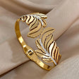 Gold leaf-shaped bracelet on a beige fabric background