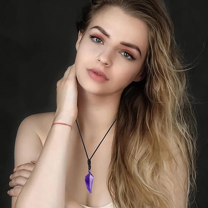 Woman wearing a necklace with a purple pendant against a dark background