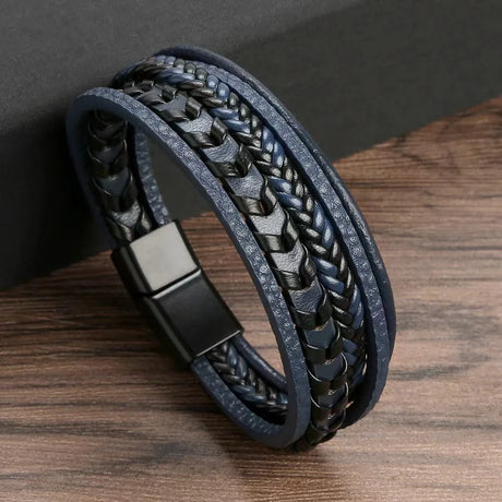 Black braided leather bracelet with metal clasp on a wooden surface